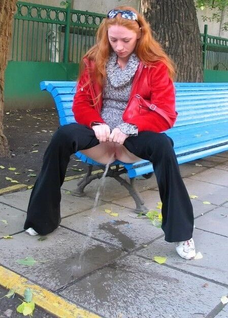 Free porn pics of Young mature redhead pulls down trousers and pisses on the stree 5 of 15 pics
